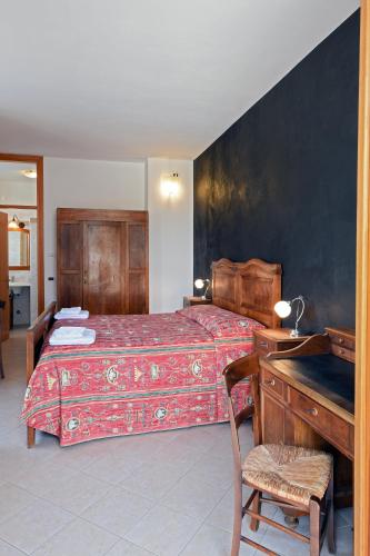 a bedroom with a bed and a desk and a bed with a red blanket at Locanda Dell'Era in Dorio