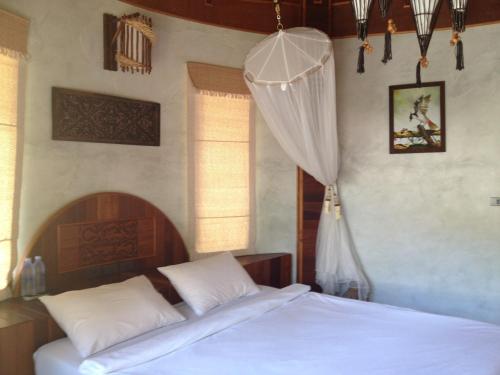 a bedroom with two white beds and a curtain at Malibu Beach Bungalows in Chaloklum