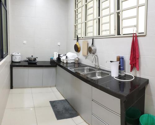 a kitchen with a sink and a counter top at De Nest Holiday home in Bayan Lepas