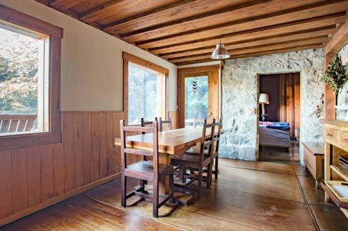 comedor con mesa de madera y sillas en Casa de campo con costa de lago en San Carlos de Bariloche