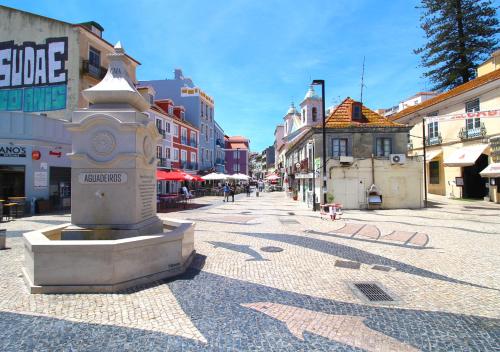 a street with a fountain in the middle of a city at Casa René - Charming apartments in Almada