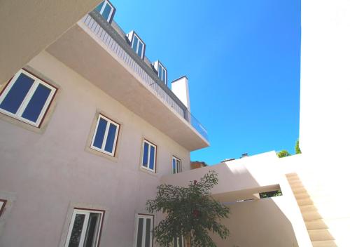 a large white building with a staircase on top of it at Casa René - Charming apartments in Almada