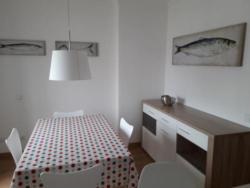 a dining room with a table and a fish picture on the wall at Casa da Sardinha in Fuzeta