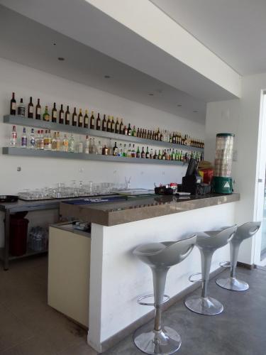 a bar with two stools and bottles on the wall at Vila Recife Hotel in Albufeira