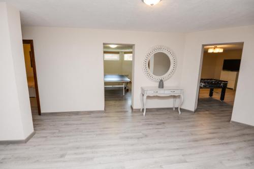 a white room with a table and a mirror at Svečių Apartamentai Vanagupėje in Palanga
