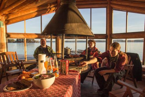 a group of people sitting at a table in a cabin at Herranniemi Guesthouse in Vuonislahti