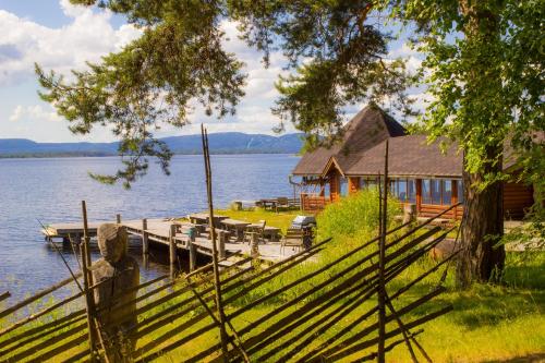a house on the shore of a lake with a dock at Herranniemi Guesthouse in Vuonislahti