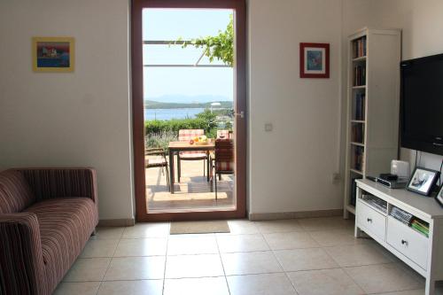 a living room with a couch and a sliding glass door at Apartments Giardino in Hvar