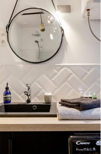 une salle de bain avec un lavabo et un miroir dans l'établissement Madame rêve, l'esquermoise, à Lille