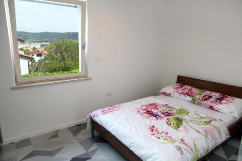 a bedroom with a bed with a window at Villa UMA in Izola