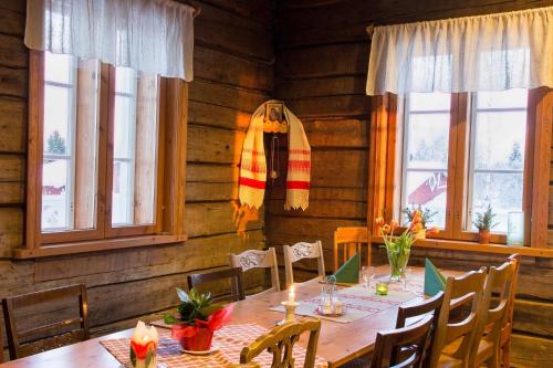 a dining room with a table and chairs and windows at Herranniemi Guesthouse in Vuonislahti
