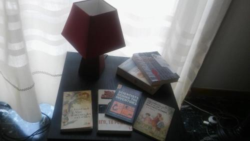 a table with books and a lamp on it at CHRYSSA - ΧΡΥΣΑ in Patra