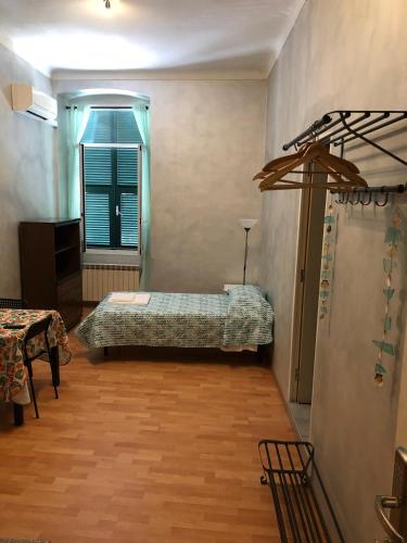 a bedroom with a bed and a table and a window at Cavour Guest House in Ventimiglia