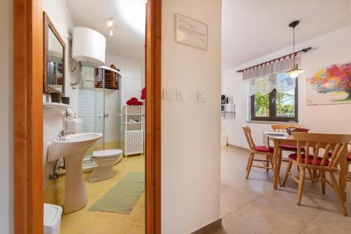 een badkamer met een wastafel, een toilet en een tafel bij Red Apartment in Vrsar