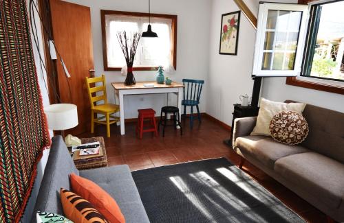 a living room with a couch and a table with chairs at Casinha à Porta in Arouca