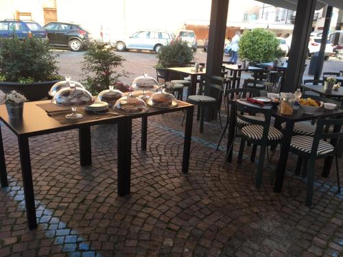 a table with plates of food on it on a patio at Vinoteca La Sacrestia in Alba