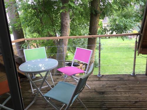 three chairs and a table on a deck at Le gite du Frene in Poses