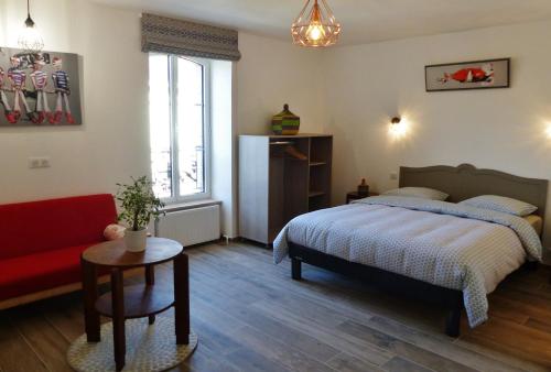 - une chambre avec un lit et un canapé rouge dans l'établissement Résidence des 14 Moulins, à Pont-Aven