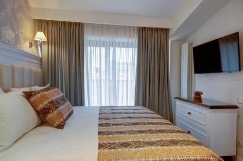a hotel room with a bed and a window at Hotel Passport Tbilisi in Tbilisi City