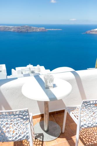 a table and chairs with a view of the ocean at Dreaming View Suites in Imerovigli