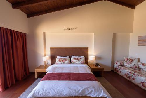 a bedroom with a large bed and two lamps at Althea Apartments in Katakolon