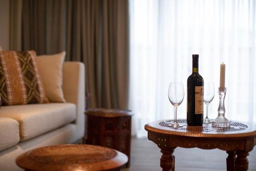 a bottle of wine and two glasses on a table in a living room at Hotel Passport Tbilisi in Tbilisi City