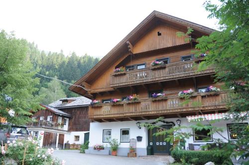 a building with a balcony with flowers on it at Gasthof Dorfschenke in Stall