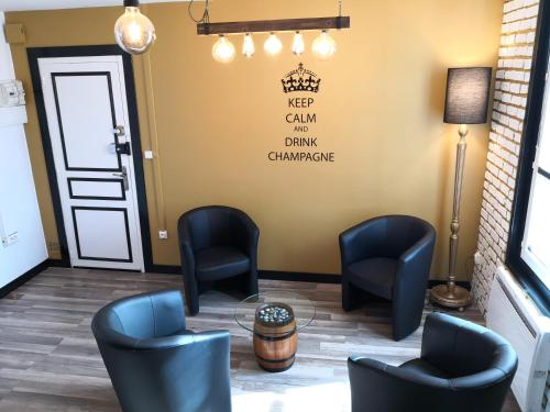 a waiting room with chairs and a table and a door at Groom Epernay - Jacuzzi & Champagne in Épernay