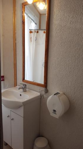 a bathroom with a sink and a mirror and a toilet at Cabañas Spa Bungalows Huarranchi in Pucón