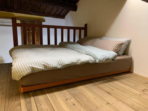 a bed sitting on a wooden floor in a room at Yamaharuka Historic House in Jinhu