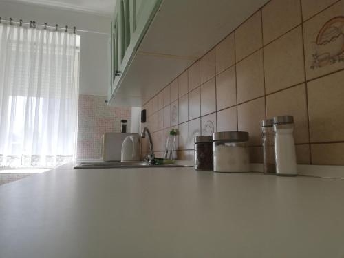 a kitchen with a white counter top and a sink at Tápé in Szeged
