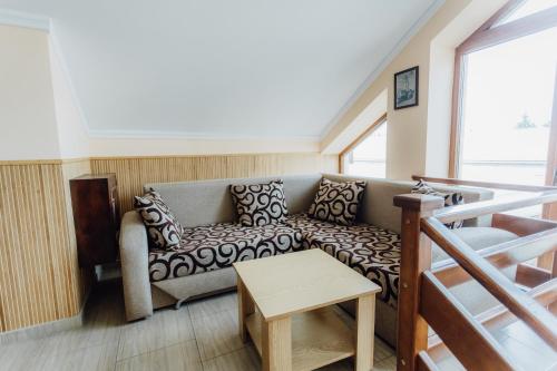 a living room with a couch and a table at Praktik Hotel & Restaurant in Berehove