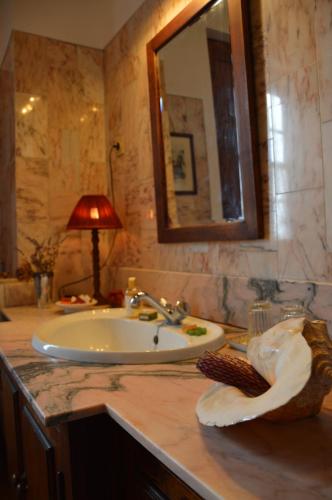a bathroom with a sink and a lamp on a counter at Casa de Cerqueda in Celorico de Basto