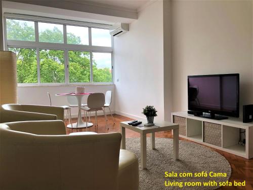 uma sala de estar com um sofá, uma televisão e uma mesa em Apartment near the airport em Lisboa