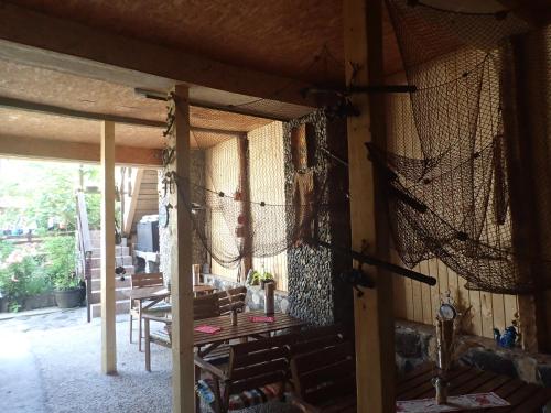 eine abgeschirmte Veranda mit einem Tisch und Stühlen in der Unterkunft Casa de Oaspeti Dunarea la Cazane in Dubova