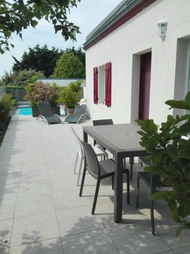 a dining table and chairs on a patio at Villa Garance Ile et Villas Groix in Groix