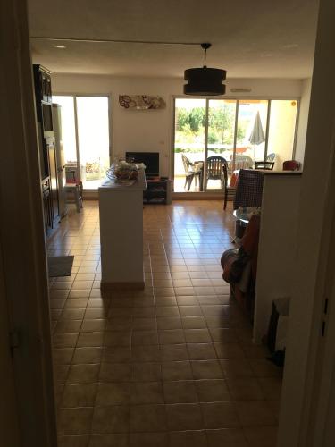 a kitchen and living room with a tile floor at Agréable F3 sur Carnon-plage à 10 mn de Montpellier in Carnon-Plage
