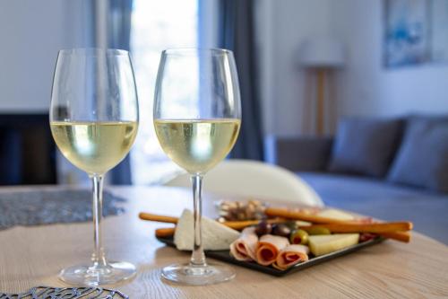 two glasses of white wine sitting on a table at Sun 'n Chill, Boutique Apartments & Beach Villa in Melíkia