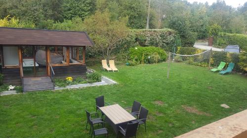 a garden with a table and chairs and a gazebo at Cabañas Spa Bungalows Huarranchi in Pucón