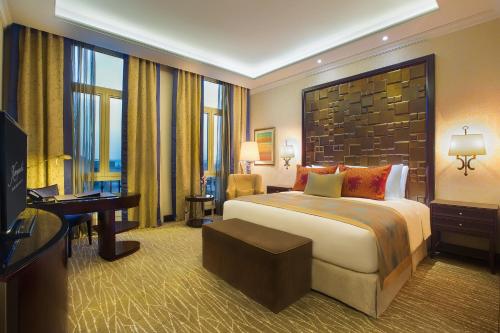 a hotel room with a large bed and a television at Royal Maxim Palace Kempinski Cairo in Cairo