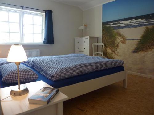 a bedroom with a bed and a table with a lamp at Ferienwohnung Landtraum in Klanxbüll