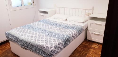 1 dormitorio con 1 cama con edredón azul y blanco en 3 Bedrooms SOHO Parking Included, en San Sebastián