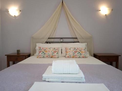 - une chambre avec un lit à baldaquin et des oreillers dans l'établissement Stamatia's Garden, à Agnontas