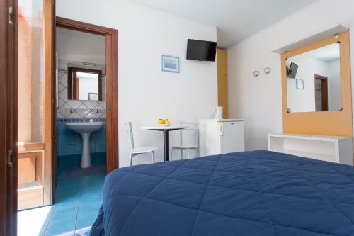 a bedroom with a blue bed and a table at Diana Brown B&B Affittacamere in Lipari