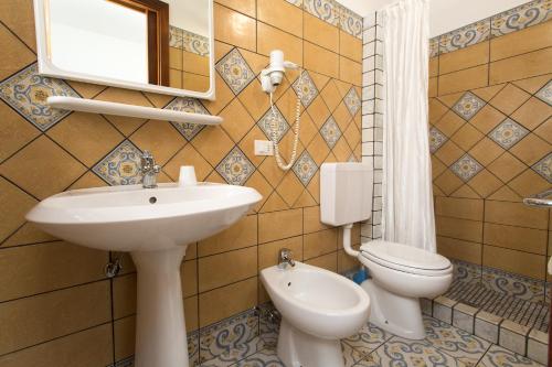 a bathroom with a sink and a toilet and a mirror at Diana Brown B&B Affittacamere in Lipari