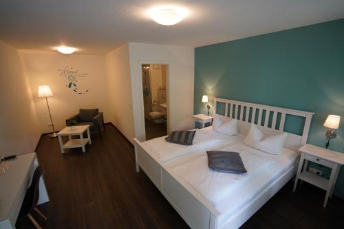 a bedroom with a large white bed with a blue wall at Busses Guesthouse in Freiburg im Breisgau