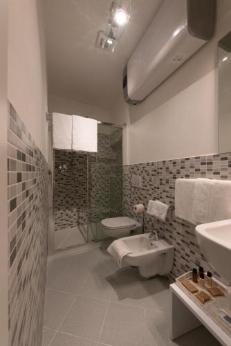 a white bathroom with a toilet and a sink at L'EMPORIO ROOMS in Manarola