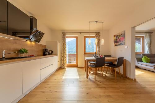 a kitchen and dining room with a table and chairs at Residence Tamperhof in San Candido