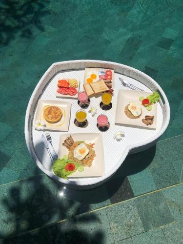 un tavolo con piatti di cibo e bevande sopra di Villa Arcadia a Gianyar