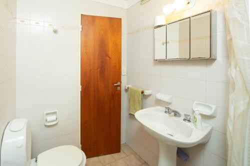 a bathroom with a toilet and a sink at Apartamento Micro Centro para 4 con cochera in Bahía Blanca